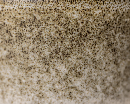 Gedetailleerde textuur van Mimo Homeware Broken Shells koffiekop in bruin, wit en beige.