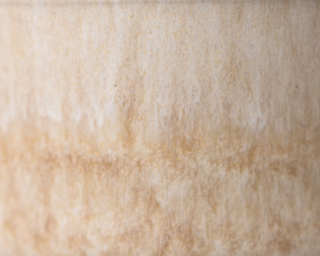 Gedetailleerde textuur van Mimo Homeware Coral Clay koffiekopje in beige en roze tinten.