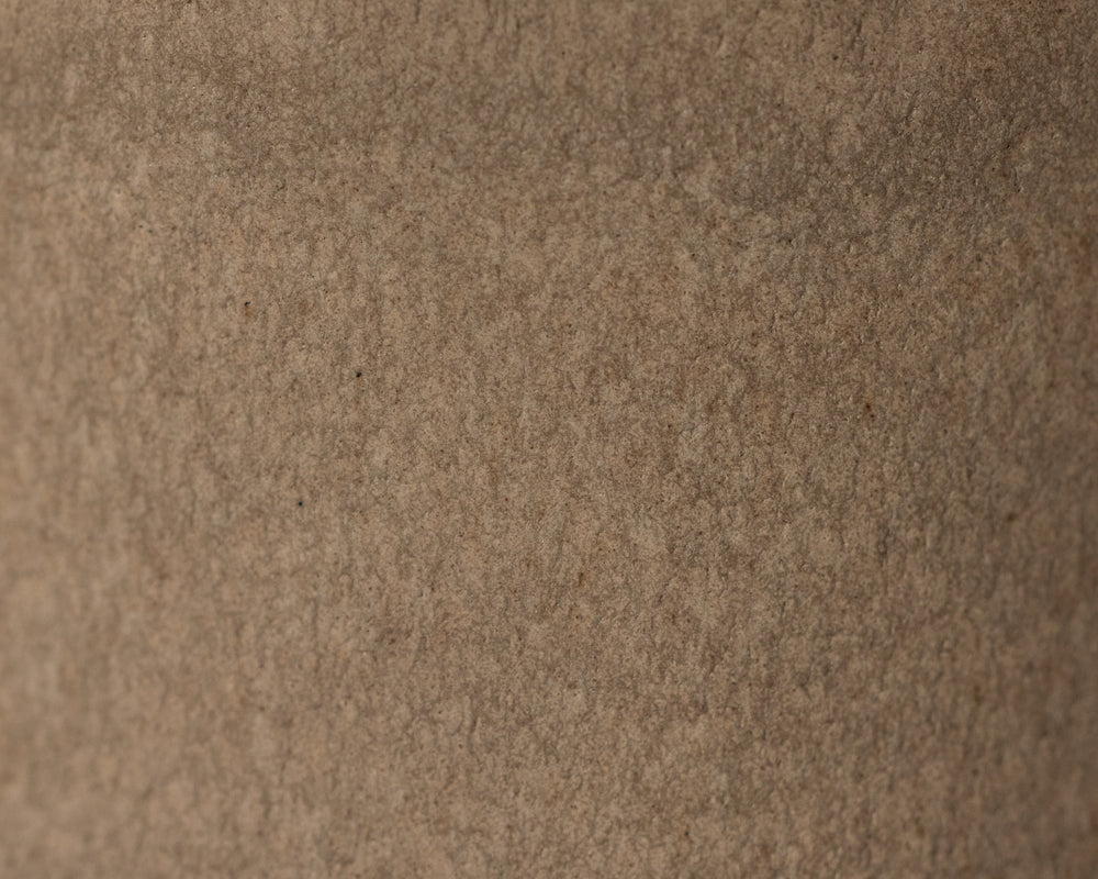Gedetailleerde textuur van Mimo Homeware On The Rocks borden, kommen en schaaltjes in bruin en beige.