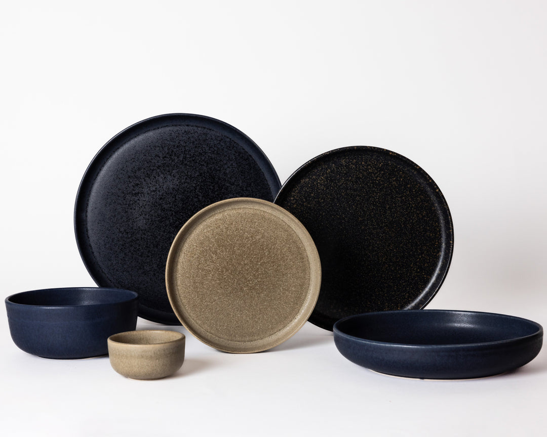 Combinatie van bruine en diepblauwe keramieken serviesdelen uit de On The Rocks en Midnight Blue collecties van Mimo.