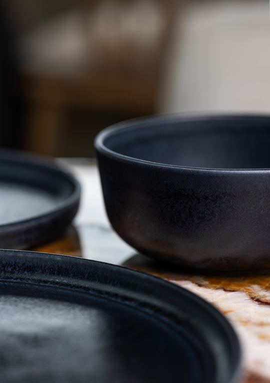 Mat donkerblauw keramiek servies van Mimo Homeware, bestaande uit een kom, dinerbord en ontbijtbord.