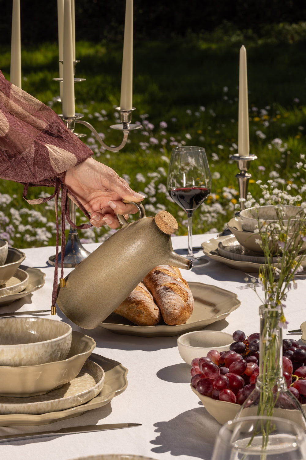 Zomerse tafelsetting met olijfolieflesje en servies van Mimo Homeware.