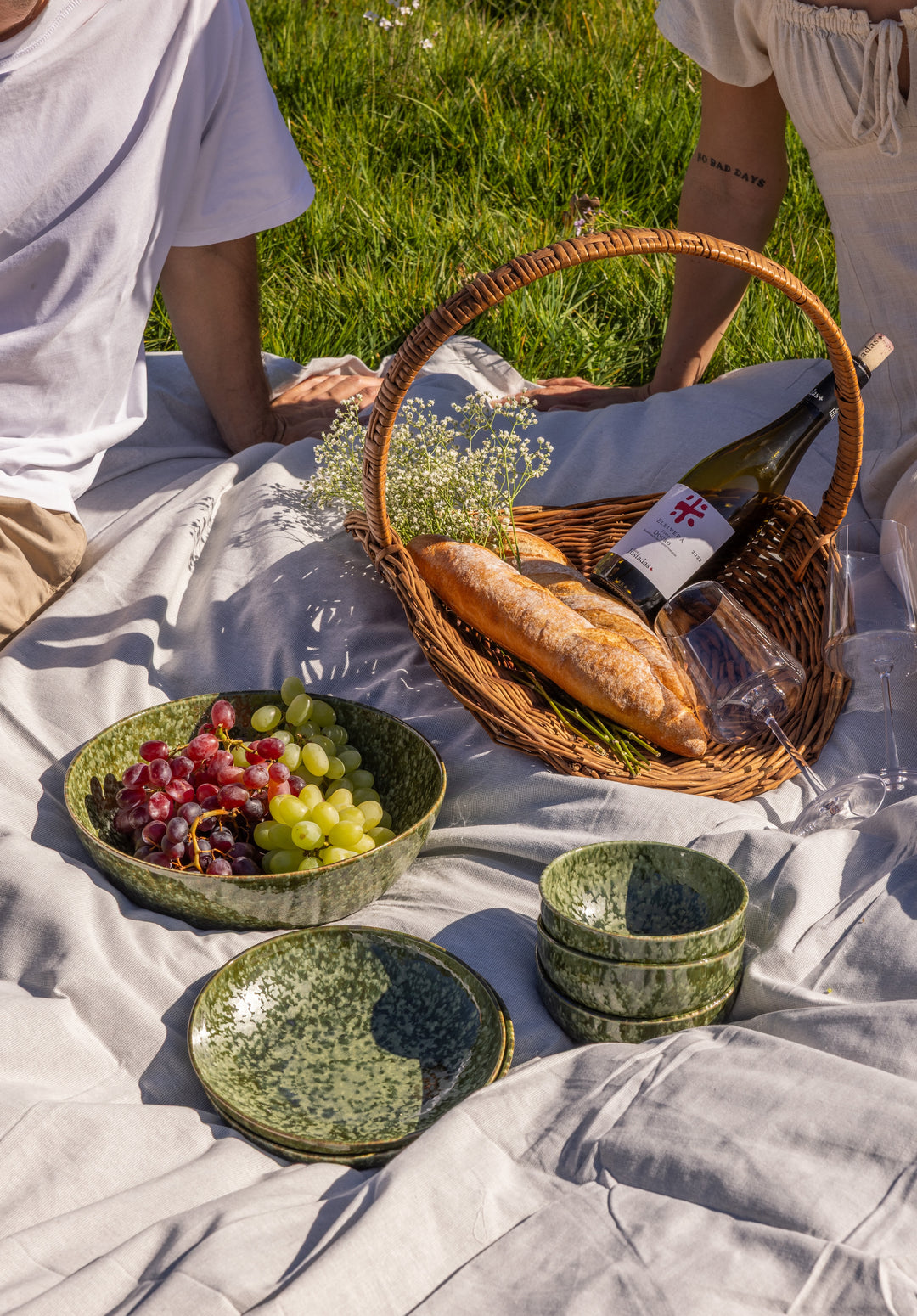 Picknick setting met donkergroene serveerschaal, borden en kommen van Mimo Homeware. Zomers servies met verschillende groene tinten.