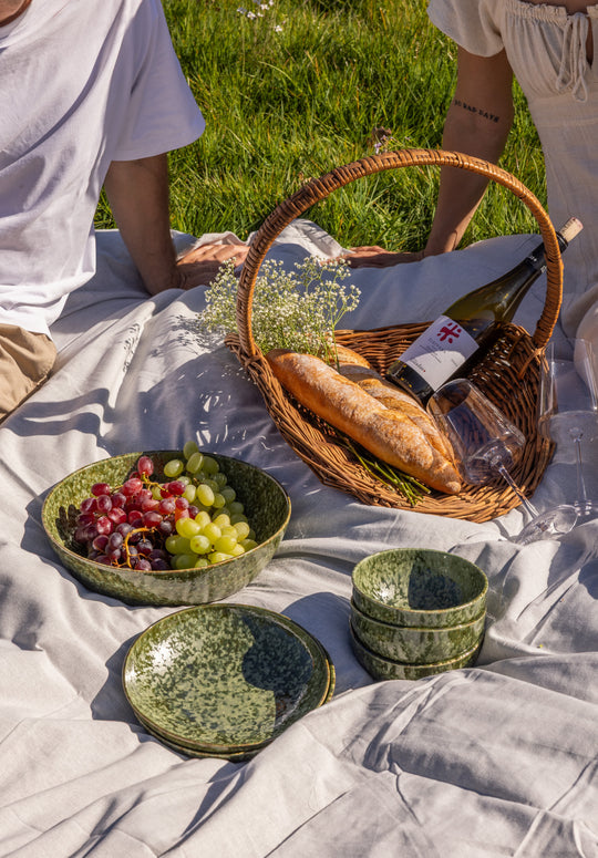 Picknick setting met donkergroene serveerschaal, borden en kommen van Mimo Homeware. Zomers servies met verschillende groene tinten.