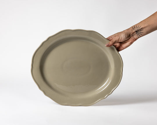 Grote platte serveerschaal van Mimo Homeware in beige en olijfgroene tinten.