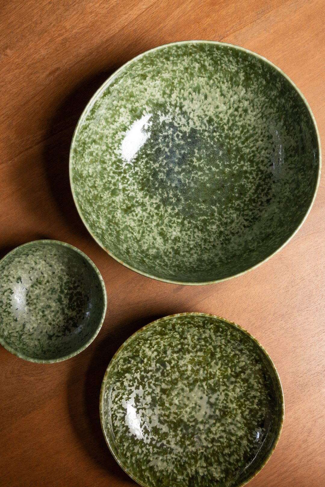 Donkergroene saladeschaal, pastabord en kom van Mimo Homeware met mat en glanzend reactief glazuur.