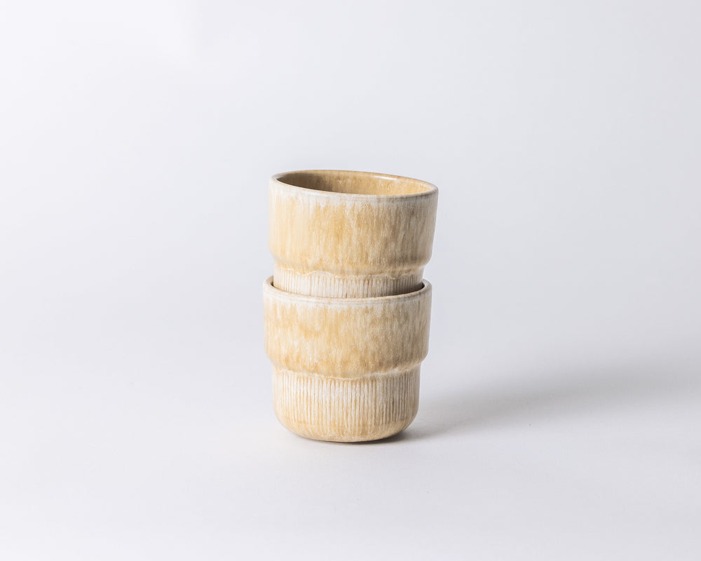 Twee Mimo koffiemokken Coral Clay in warme zandtint, stapelbaar en Scandinavisch geïnspireerd.