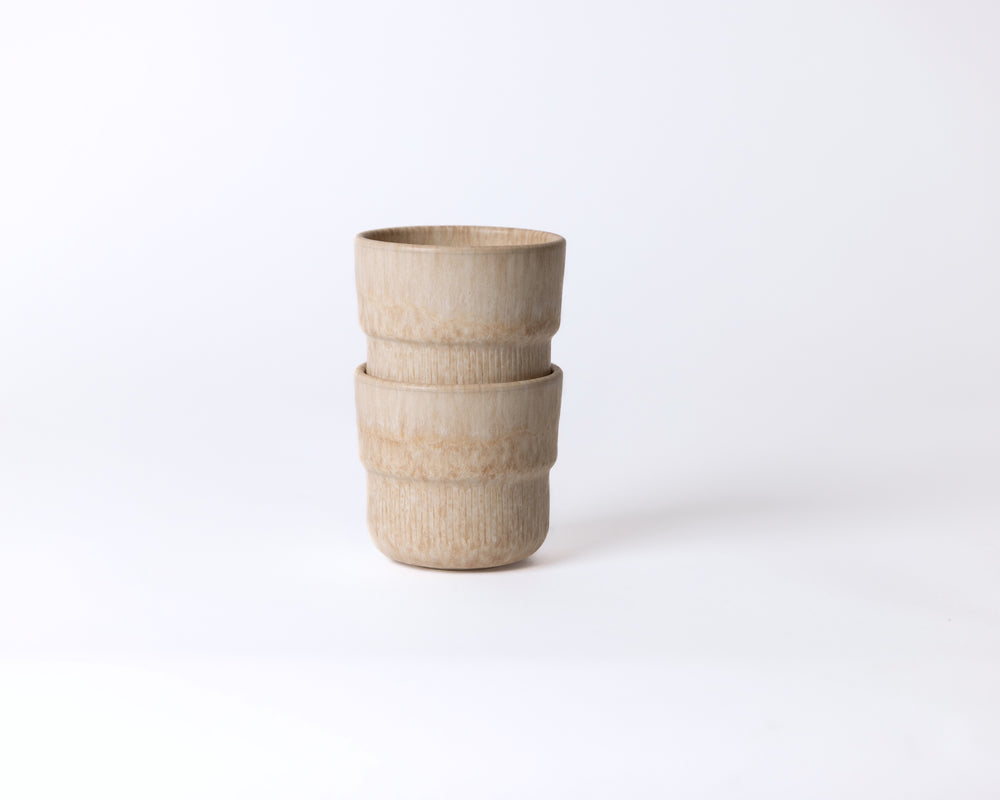 Twee Mimo koffiemokken Coral Clay in warme zandtint, stapelbaar en Scandinavisch geïnspireerd.