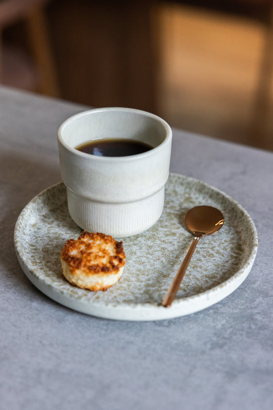 Dreamy Ivory koffiekopje van Mimo Homeware op Mini Bord Broken Shells met gouden lepel en koekje.