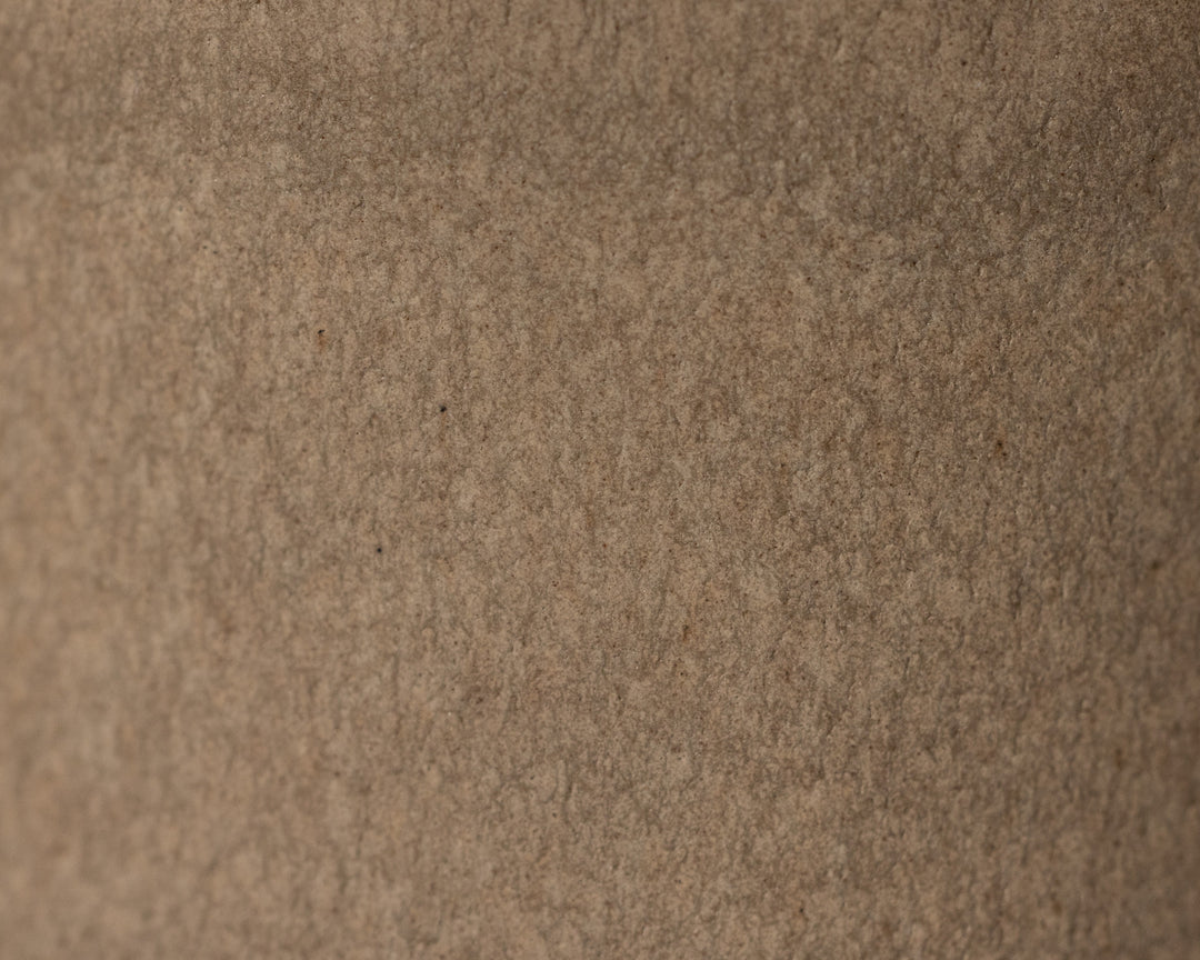 Gedetailleerde textuur van Mimo Homeware On The Rocks koffiekopje in bruin en beige.