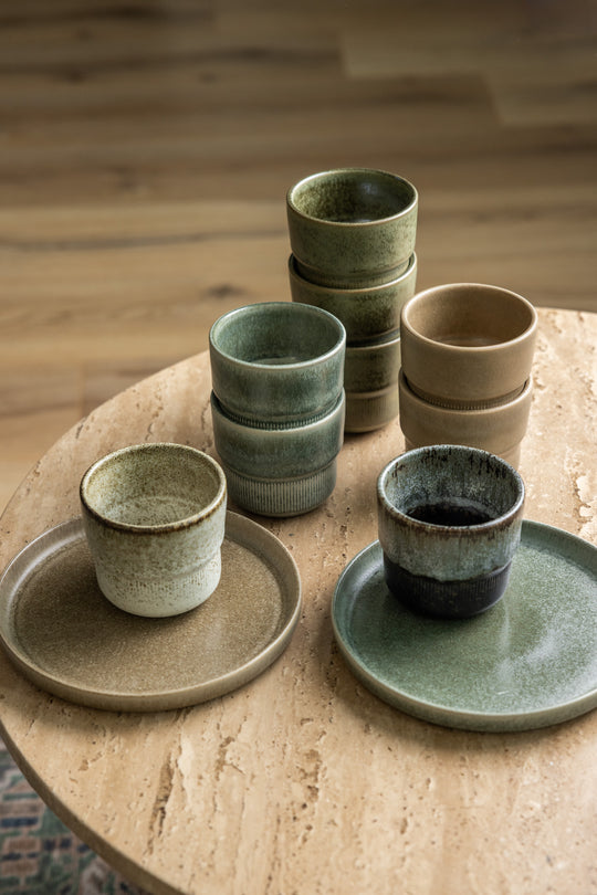 Meerdere koffiekopjes met mini borden van Mimo Homeware, in natuurlijke kleuren van de zee, rotsen, bossen en de aarde. Perfect voor een natuurlijk interieur.