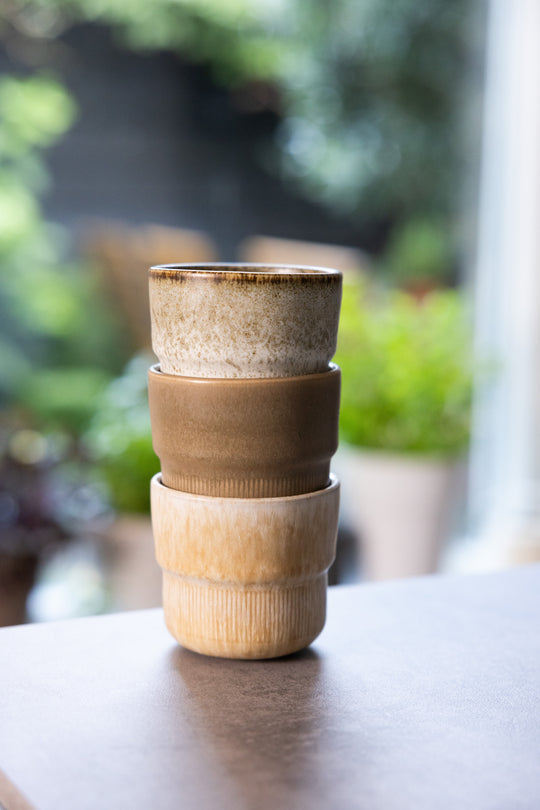 Drie licht- en natuurkleurige koffiekopjes zonder oor, van Mimo Homeware, met een natuurlijke achtergrond.