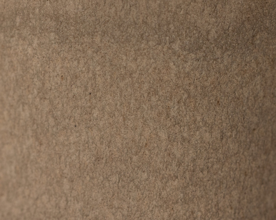 Gedetailleerde textuur van Mimo Homeware On The Rocks borden, kommen en schaaltjes in bruin en beige.