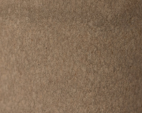 Gedetailleerde textuur van Mimo Homeware On The Rocks borden, kommen en schaaltjes in bruin en beige.